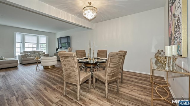 dining room with wood finished floors, an inviting chandelier, and baseboards