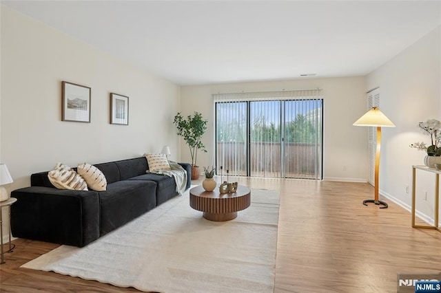 living area featuring baseboards and wood finished floors