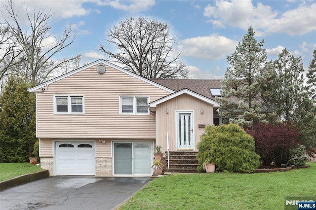 view of front facade with a shingled roof, an attached garage, brick siding, a front lawn, and driveway
