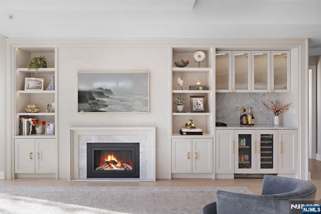 bar featuring built in features, a dry bar, beverage cooler, and a high end fireplace