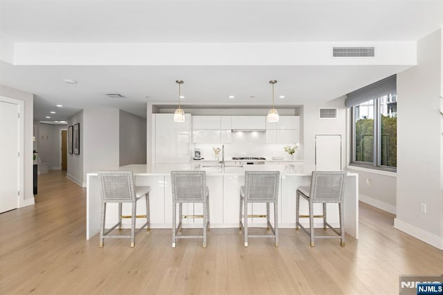 kitchen featuring white cabinets, light countertops, modern cabinets, and visible vents