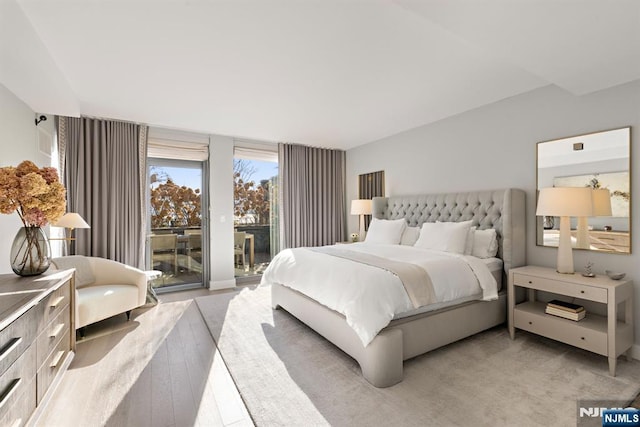 bedroom featuring access to exterior and light colored carpet