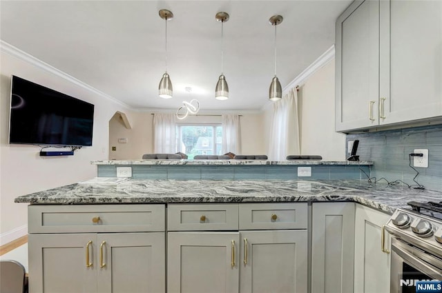 kitchen with light stone counters, stainless steel gas range, backsplash, ornamental molding, and pendant lighting