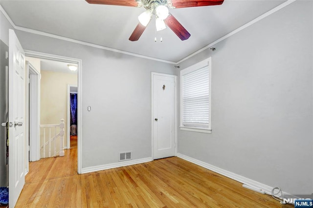 unfurnished bedroom featuring baseboards, light wood-type flooring, crown molding, and ceiling fan