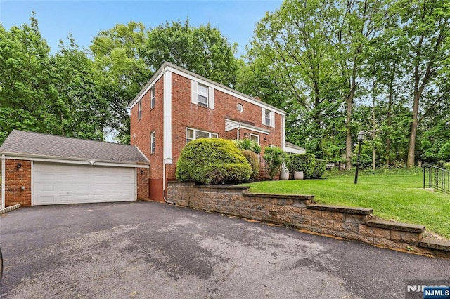 view of front of property featuring brick siding, a front lawn, and driveway