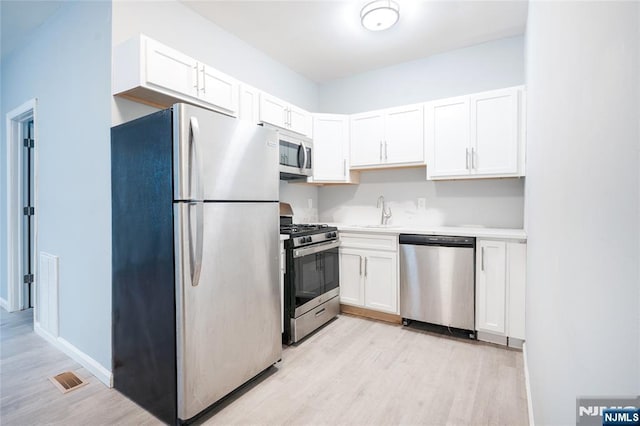 110 Montgomery St, Paterson, NJ 07501 - kitchen featuring a sink, light countertops, appliances with stainless steel finishes, and white cabinets