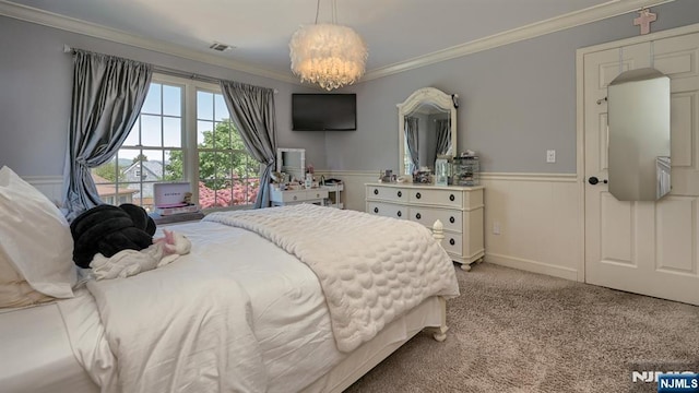 bedroom featuring an inviting chandelier, a wainscoted wall, ornamental molding, and carpet flooring
