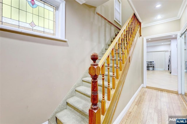 staircase featuring baseboards, crown molding, hardwood / wood-style floors, and recessed lighting