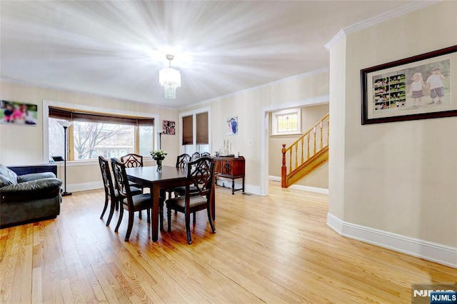 dining room with baseboards, a chandelier, stairs, and light wood finished floors