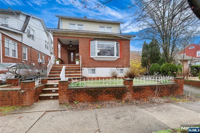 bungalow-style house with brick siding and a fenced front yard