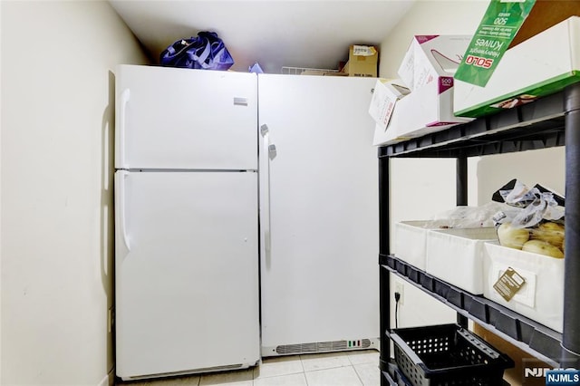 kitchen with freestanding refrigerator and light tile patterned floors