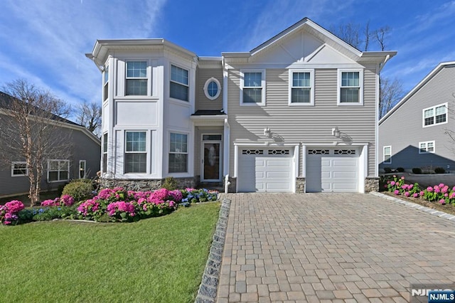 23 Arden Pl, Hillsdale, NJ 07642 - view of front of home with a front yard, stone siding, decorative driveway, and an attached garage