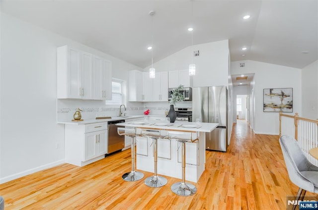 kitchen with white cabinets, light wood-style floors, light countertops, and appliances with stainless steel finishes