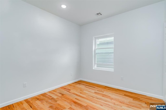 spare room with light wood finished floors, baseboards, visible vents, and recessed lighting