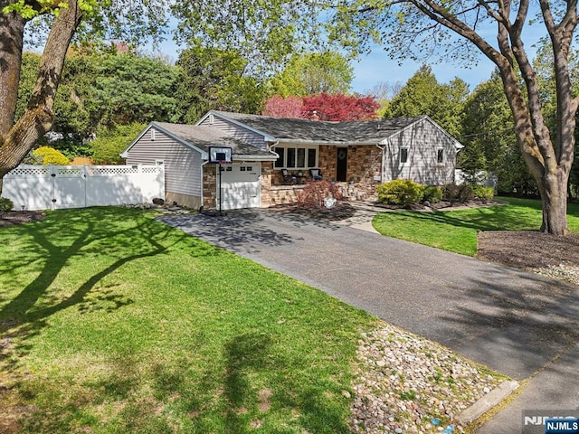 ranch-style home featuring driveway, stone siding, an attached garage, fence, and a porch
