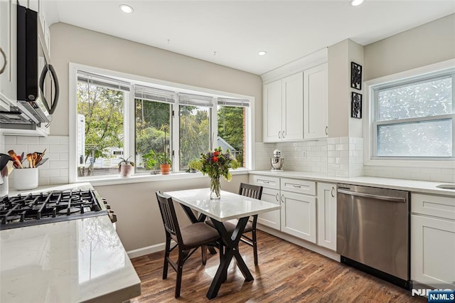kitchen with wood finished floors, recessed lighting, white cabinets, and stainless steel appliances