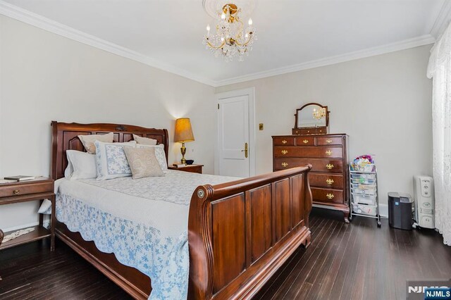 bedroom with a chandelier, dark wood-type flooring, crown molding, and baseboards