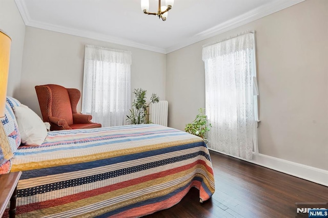 bedroom with crown molding, radiator heating unit, wood finished floors, a notable chandelier, and baseboards