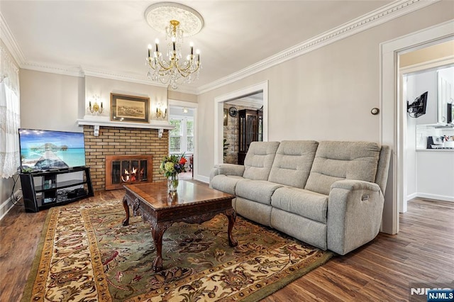 living room featuring baseboards, an inviting chandelier, a fireplace, crown molding, and wood finished floors
