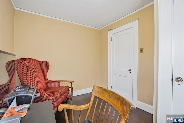 sitting room with baseboards, crown molding, and wood finished floors