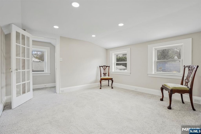 sitting room with a healthy amount of sunlight, baseboards, and lofted ceiling