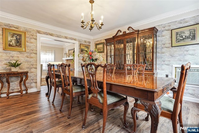 dining room with baseboards, wallpapered walls, ornamental molding, a chandelier, and wood finished floors