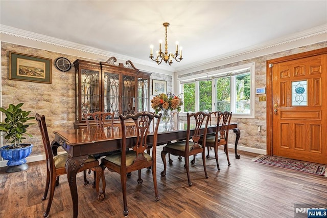 dining space featuring a notable chandelier, baseboards, ornamental molding, and wood finished floors
