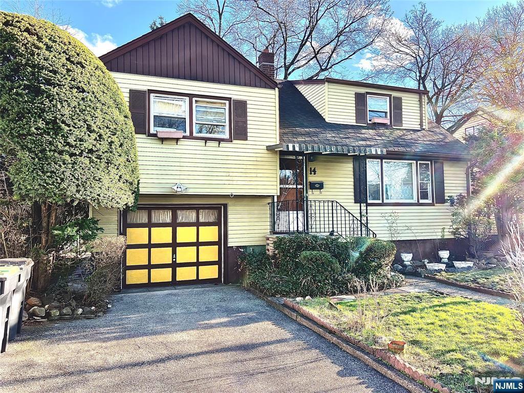 view of front of house with a garage, aphalt driveway, and a chimney