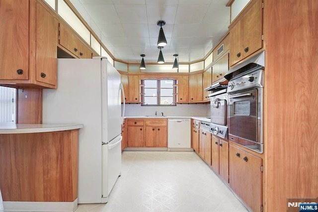 kitchen featuring visible vents, a sink, light countertops, light floors, and white appliances