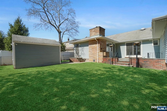 view of yard with fence, an outbuilding, and a shed