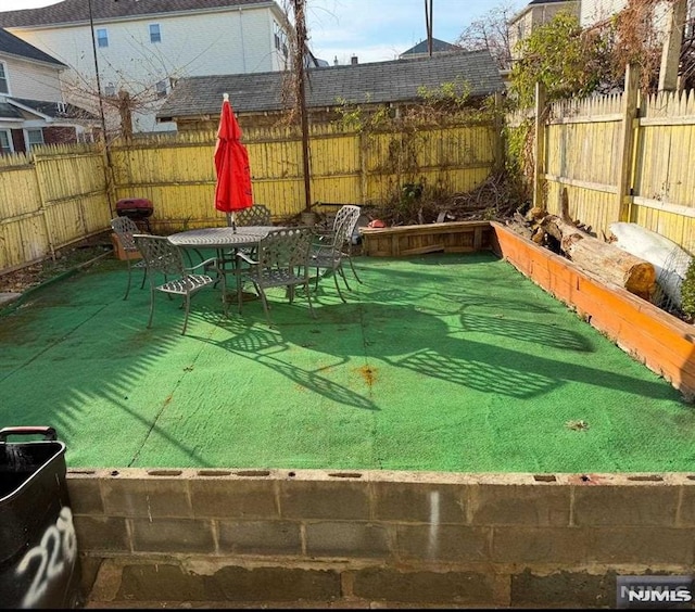 view of yard with outdoor dining space and a fenced backyard