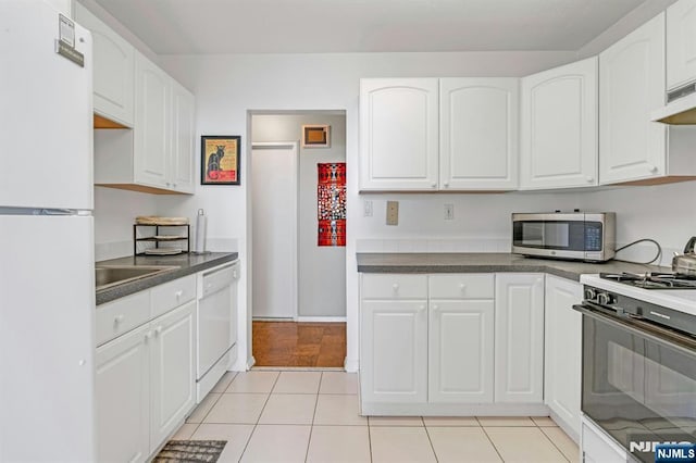 2150 Center Ave Unit 19A, Fort Lee, NJ 07024 - kitchen featuring white appliances, white cabinets, dark countertops, under cabinet range hood, and light tile patterned floors