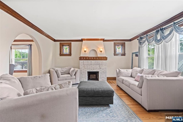 126 Beech St, Nutley, NJ 07110 - living area featuring ornamental molding, arched walkways, a fireplace, light wood finished floors, and baseboards