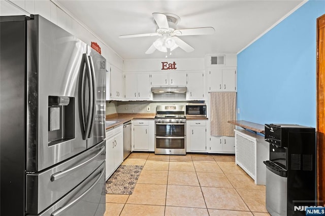 126 Beech St, Nutley, NJ 07110 - kitchen featuring appliances with stainless steel finishes, under cabinet range hood, white cabinets, light tile patterned floors, and a ceiling fan