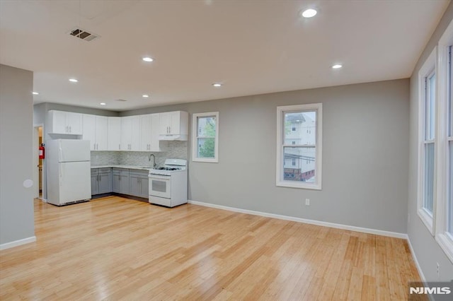 229 21st St, Irvington, NJ 07111 - kitchen with white appliances, tasteful backsplash, light wood-type flooring, a sink, and baseboards