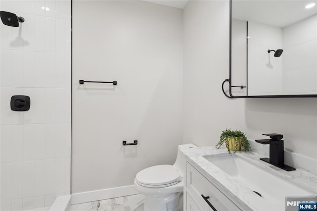 bathroom featuring marble finish floor, toilet, vanity, baseboards, and walk in shower