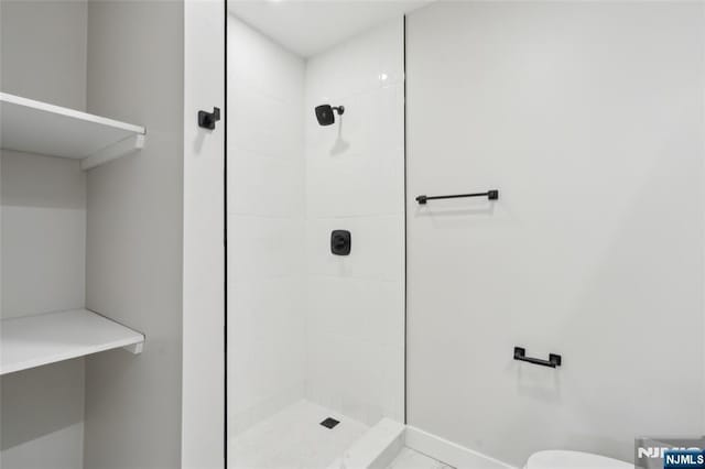 bathroom with toilet and tiled shower