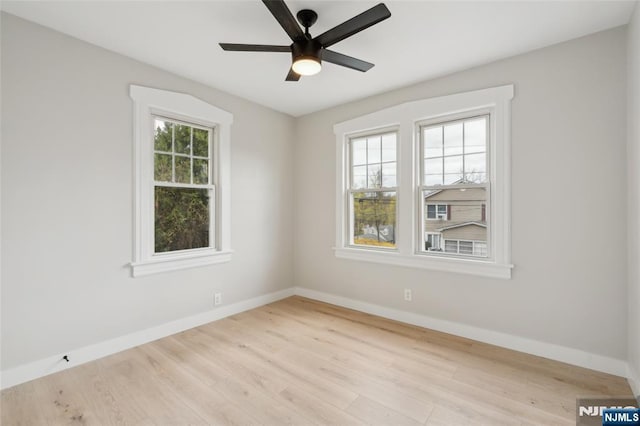 empty room with wood finished floors, baseboards, and ceiling fan