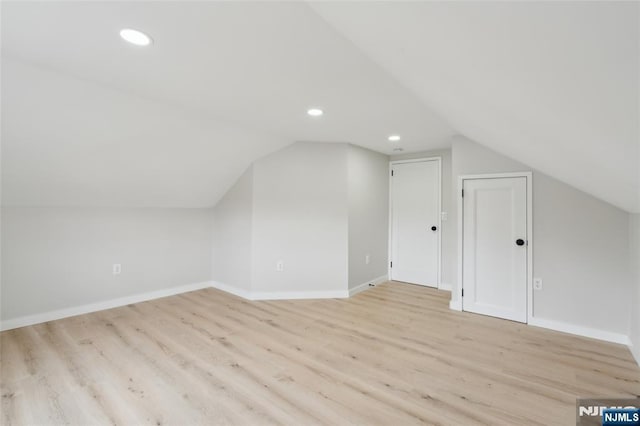 additional living space with recessed lighting, lofted ceiling, wood finished floors, and baseboards