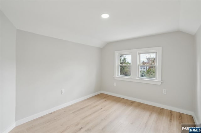 interior space featuring recessed lighting, lofted ceiling, wood finished floors, and baseboards