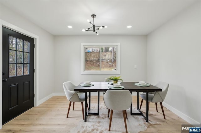 dining space with recessed lighting, baseboards, a notable chandelier, and light wood-type flooring