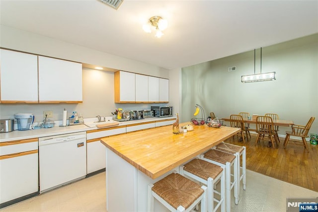 79 Adams Ter Unit 79, Clifton, NJ 07013 - kitchen with visible vents, white cabinets, white dishwasher, a breakfast bar, and stainless steel microwave