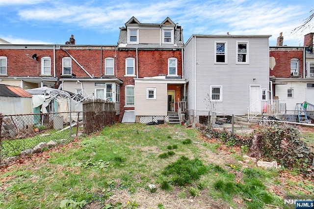 back of property with entry steps and fence