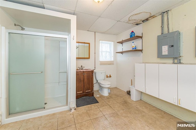 full bathroom featuring a paneled ceiling, a shower stall, vanity, electric panel, and toilet