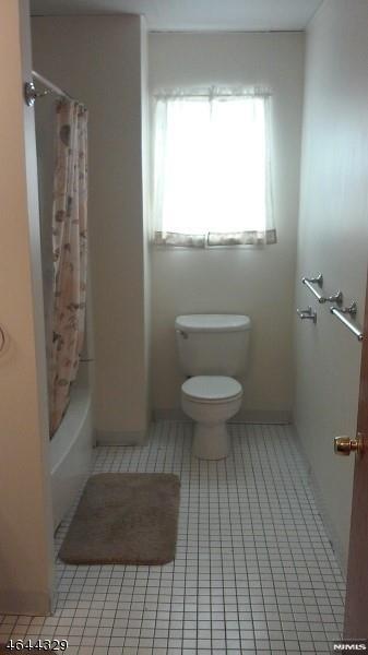 full bath featuring toilet and tile patterned floors