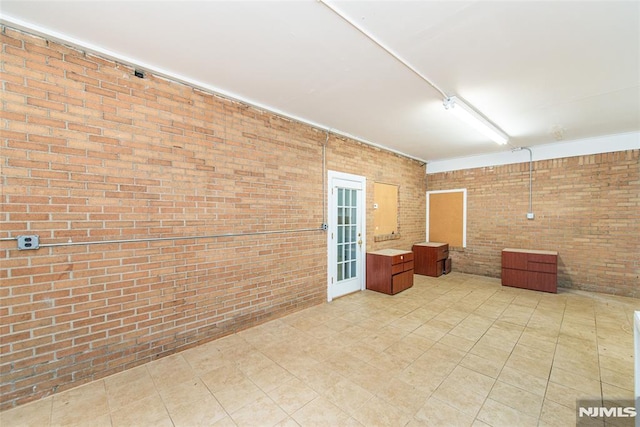 unfurnished room featuring brick wall