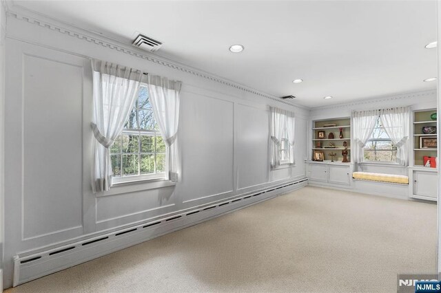 carpeted spare room with a baseboard heating unit, plenty of natural light, visible vents, and recessed lighting