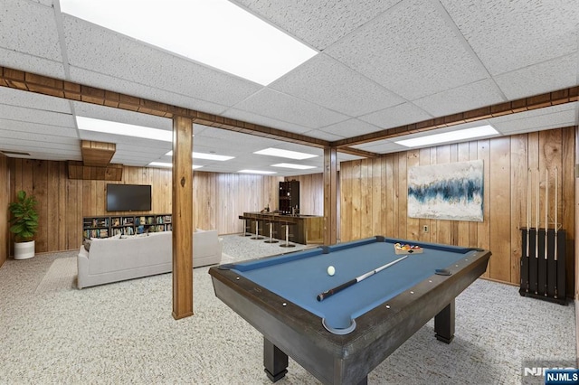 game room featuring a paneled ceiling, wood walls, and pool table