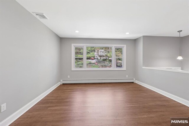empty room featuring visible vents, wood finished floors, baseboards, a baseboard heating unit, and recessed lighting