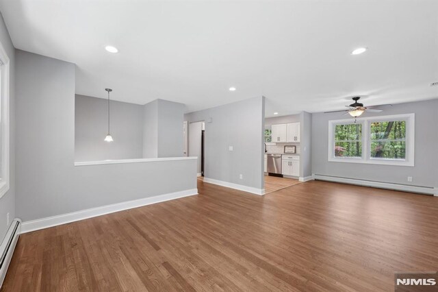 unfurnished living room with ceiling fan, light wood-style flooring, baseboards, a baseboard radiator, and a baseboard heating unit